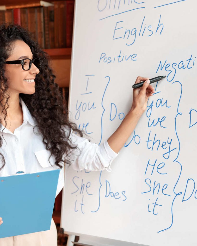 english-teacher-standing-at-whiteboard-explaining-2022-12-16-07-35-58-utc (1)